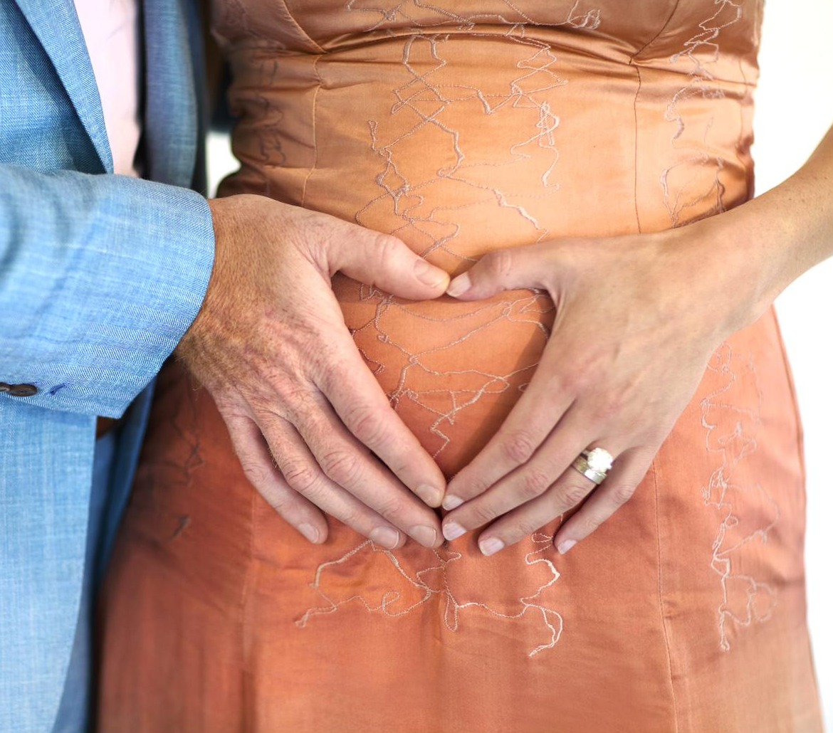 Chris's hand on Jenna's belly in the English garden